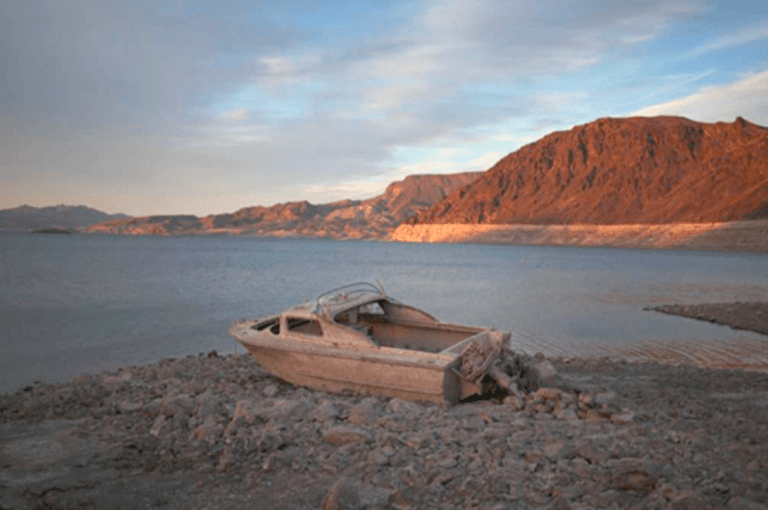 A formerly sunken boat sits high and dry along the shoreline of Lake Mead at the Lake Mead National Recreation Area